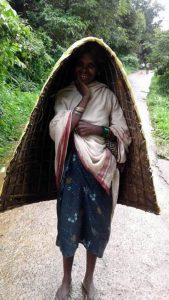 An old tribe woman wearing a traditional natural umbrella